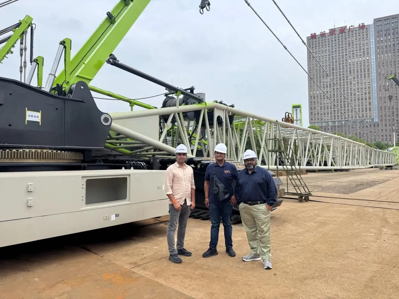 Engineers beside a crawler crane boom at a hybrid project site