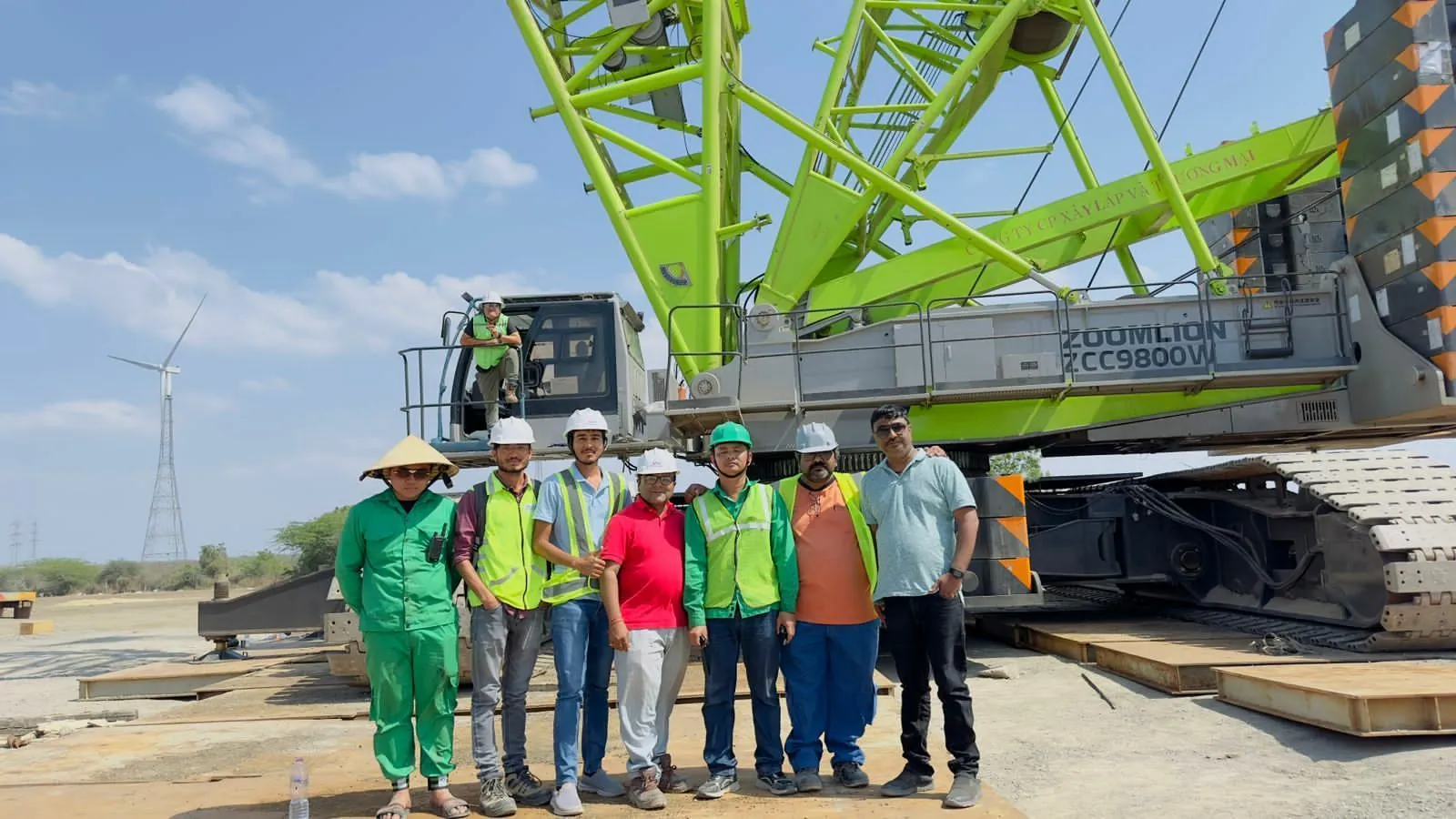 Greentech site team in front of a crawler crane at a wind farm